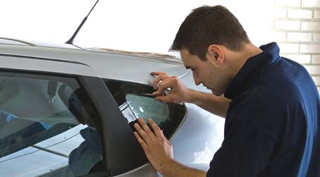 man repairing car window